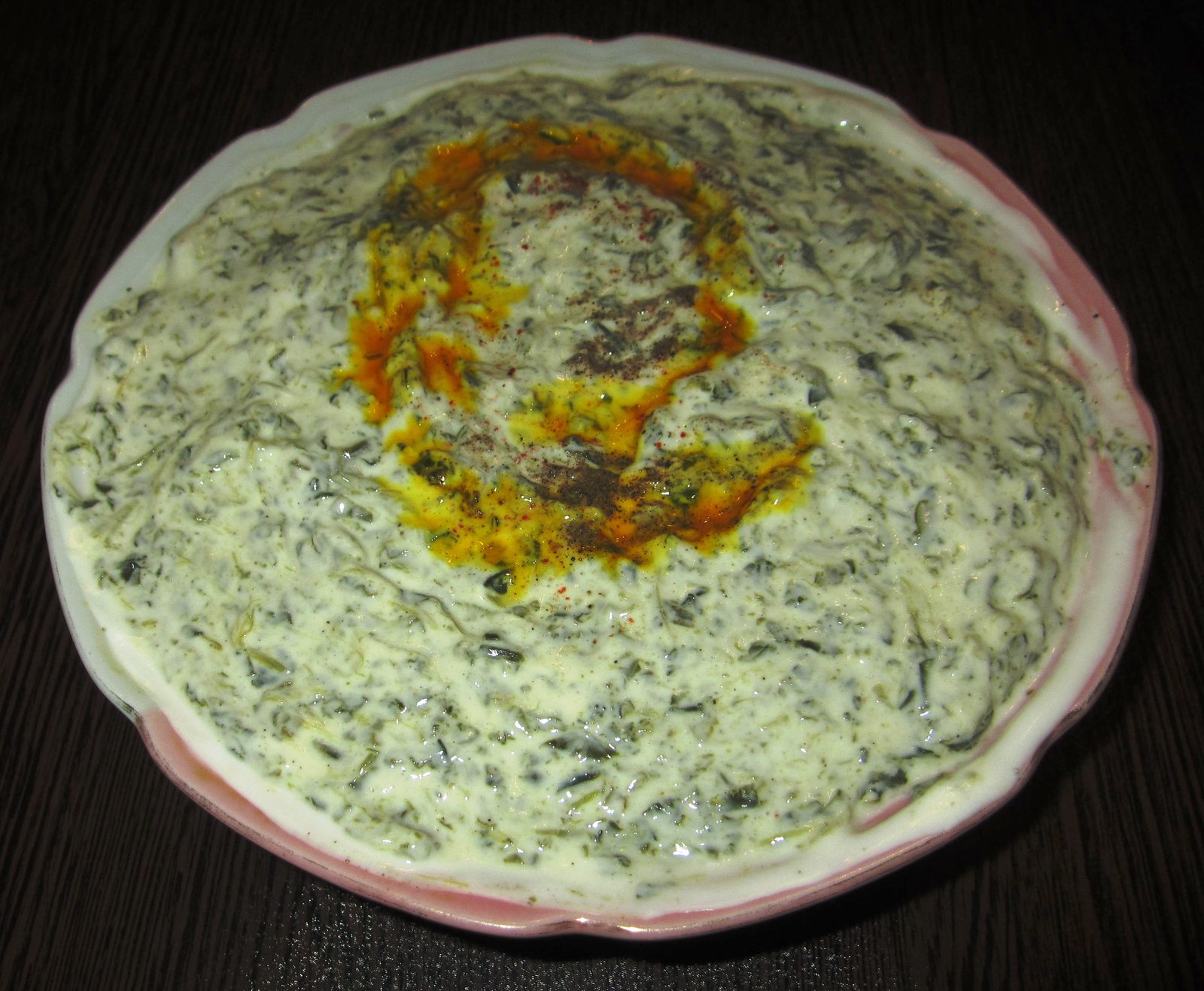 Borani-e esfenaj : épinards au yaourt dressés en assiette, nappés d'un filet d'huile safranée