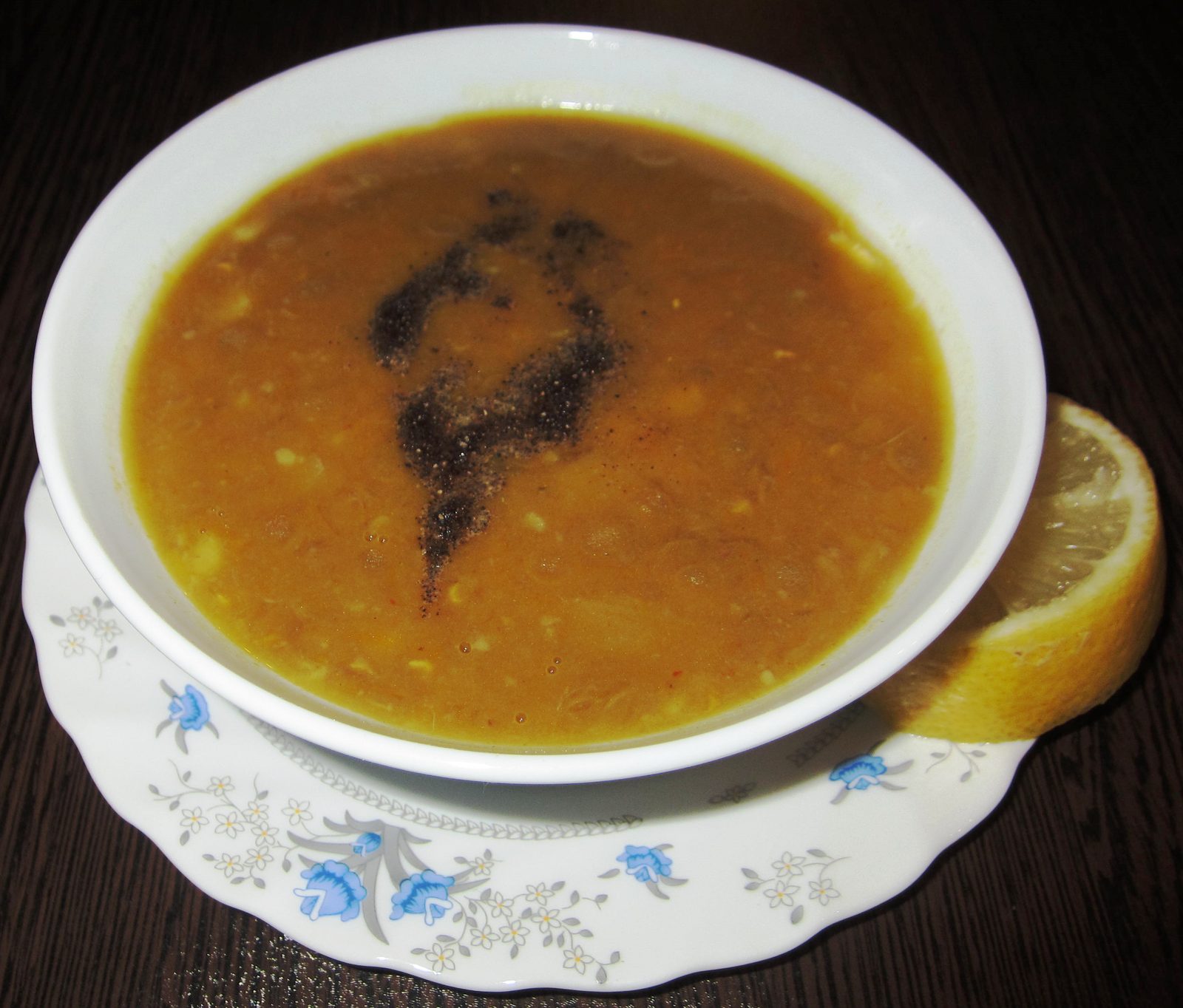 Bol d'adasi : plat de lentilles iranien épais, poivré, servi avec un quartier de citron