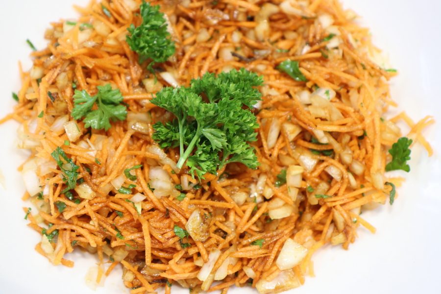 Salade de carottes râpées à l'oignon et au persil, dans une assiette blanche